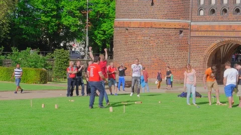 Friends spending time together while playing on glade near Holsten Gate, Luebeck Stock Footage 80959278
