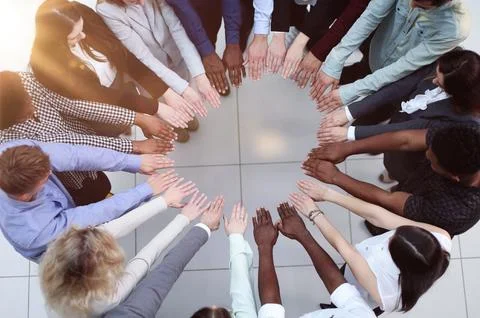 Friends with stack of hands showing unity and teamwork. Stock Photos