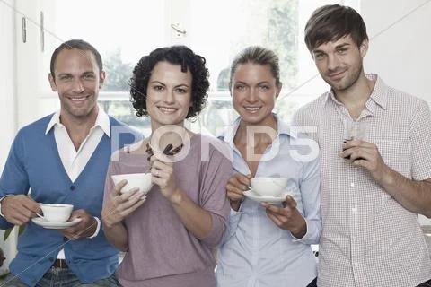 Friends standing in a row and smiling Stock Photos