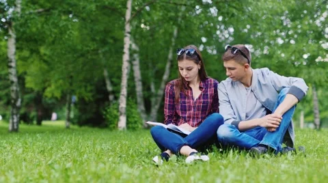Friends - students read book in the park Vídeos de archivo 63349082