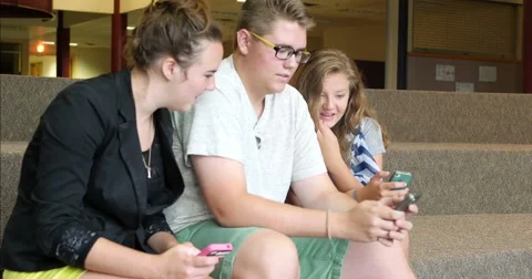 Friends (students) using their smart cell phones in school. Ultra HD 4K Stock Footage 45575264