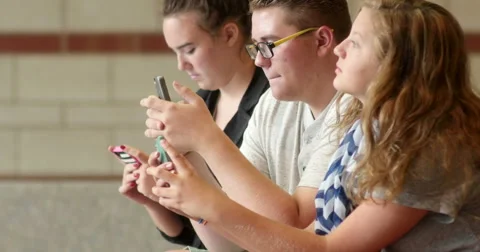 Friends (students) using their smart cell phones in school. Ultra HD 4K Stock Footage 45576736