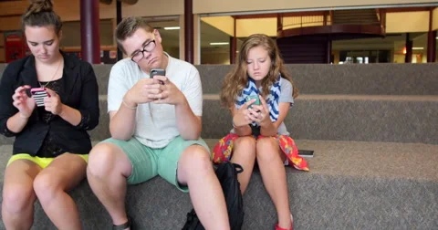 Friends (students) using their smart cell phones in school. Ultra HD 4K Stock Footage 45620957