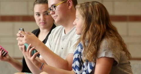 Friends (students) using their smart cell phones in school. Ultra HD 4K Stock Footage 45621175