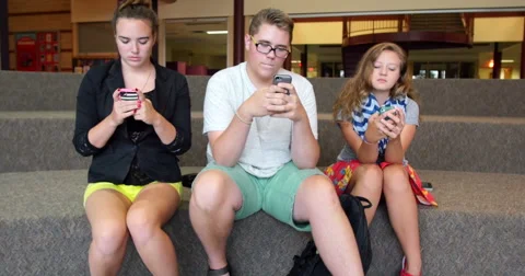 Friends (students) using their smart cell phones in school. Ultra HD 4K Stock Footage 45650254