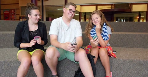 Friends (students) using their smart cell phones in school. Ultra HD 4K Stock Footage 45650536