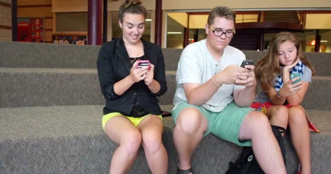 Friends (students) using their smart cell phones in school. Ultra HD 4K Stock Footage 45650781