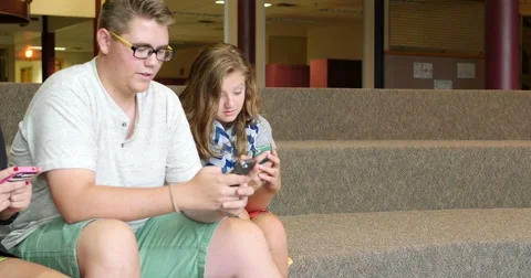 Friends (students) using their smart cell phones in school. Ultra HD 4K Stock Footage 45651385