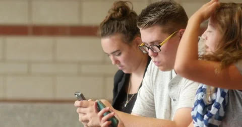 Friends (students) using their smart cell phones in school. Ultra HD 4K Stock Footage 45651614
