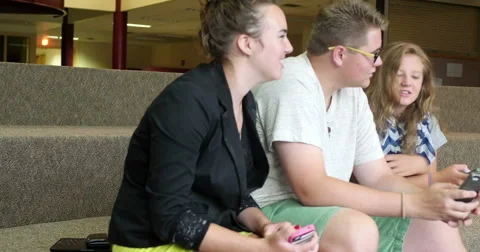 Friends (students) using their smart cell phones in school. Ultra HD 4K Video stock 46599509