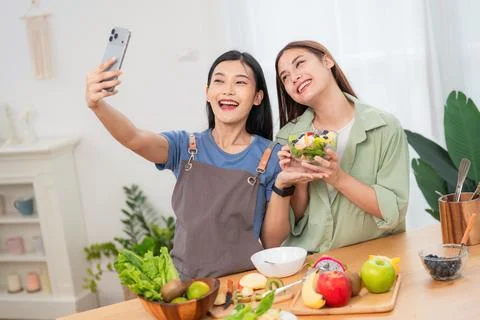 Friends take selfie while preparing healthy meal in modern kitchen during d.. Stock Photos