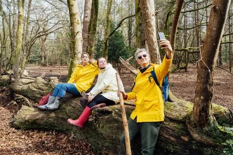Friends taking selfies while resting during forest hiking with backpacks Stock Photos