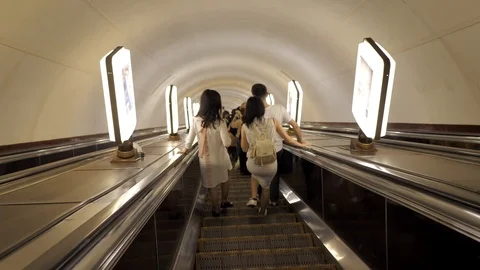 Friends talking and walking down the escalator in the subway. 스톡 동영상 124307710