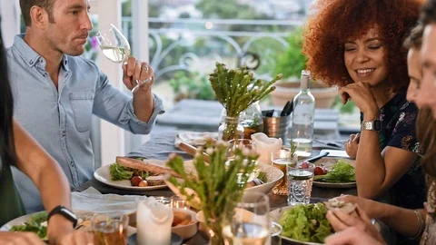 Friends talking around dinner table Stock Footage 71607869