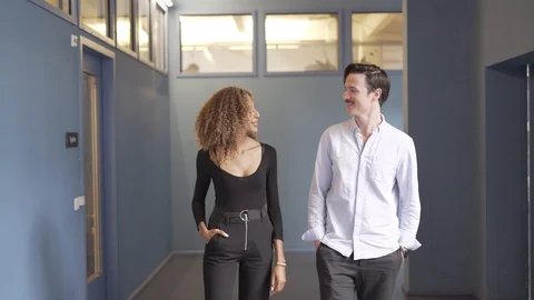Friends talking while walking in the corridor Stock Footage 114877639