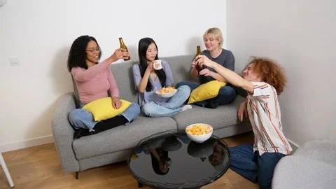 Friends toasting with bottles of beer on a couch Stock Footage 306216242