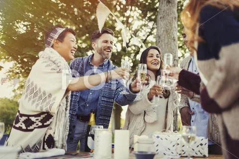 Friends toasting champagne glasses at patio table Stock Photos