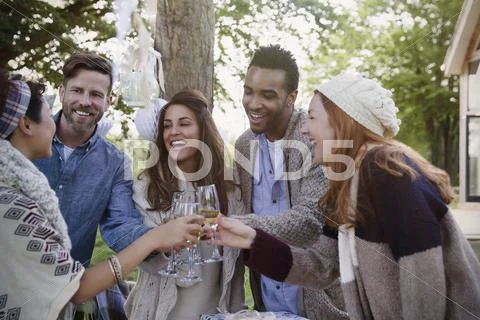 Friends toasting champagne glasses on patio Stock Photos