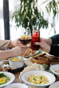 Friends Toasting Drinks at Dining Table During Social Gathering Stock Photos