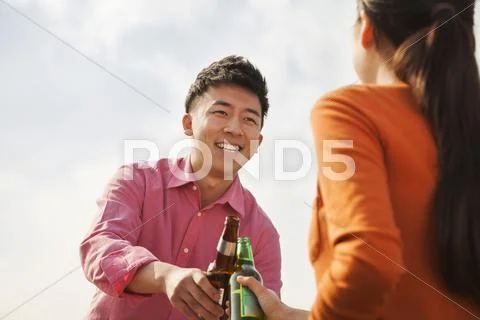 Friends Toasting Each Other on a Rooftop Stock Photos