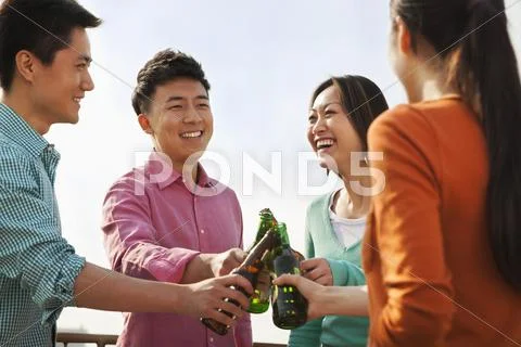 Friends Toasting Each Other on a Rooftop Stock Photos