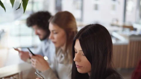 Friends using cell phones in a coffee shop, not talking to eachother and look Video stock 190408900