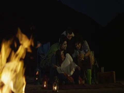 Friends using mobile around campfire. Stock Footage 69471840
