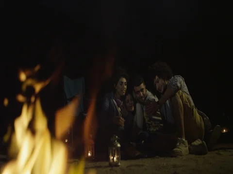 Friends using mobile around campfire. Stock Footage 69474704