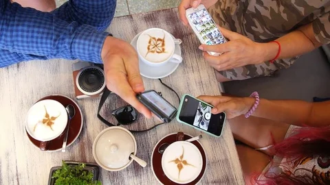 Friends Using Mobile Phones Drinking Coffee in Cafe Video stock 74259043