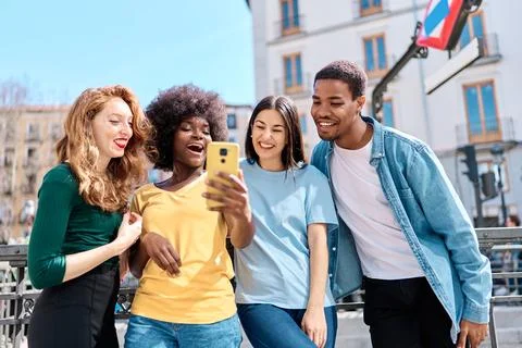 Friends using a mobile while visiting a city Stock Photos