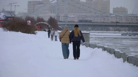 Friends Walking Along Snowy River Promenade in City Winter With Bridge and Skyli Stock Footage 331237338