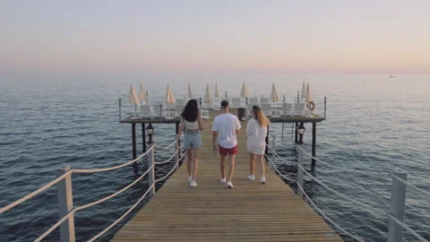 Friends Walking on a Pier Overlooking the Sea Stock Footage 282927807