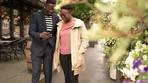 Friends walking in the street while watching at the cellphone Video stock 155651769