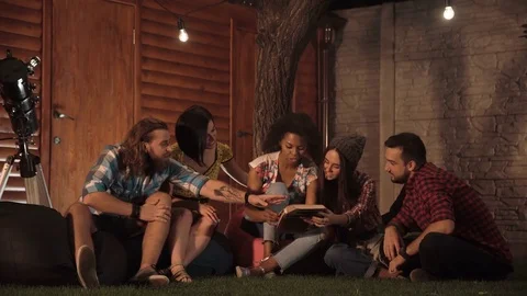 Friends watching album together and laugh Stock Footage