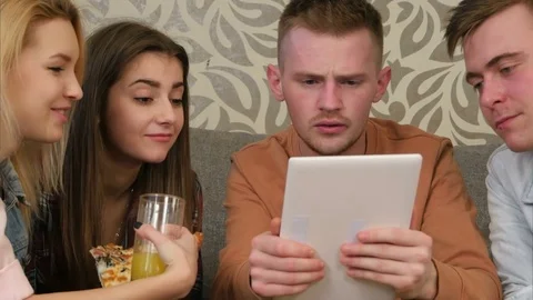 Friends watching comedy programm, using tablet, and laughing Video stock 73481927