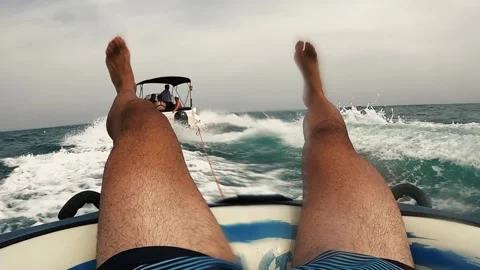 Friends water skiing over inflatable donut pulled by boat 库存影片 246792184