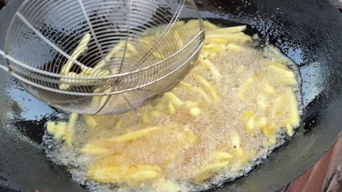 Fries in bulk in a large pan. Making bulk fries in pan full of oil. Stock Footage 296891117