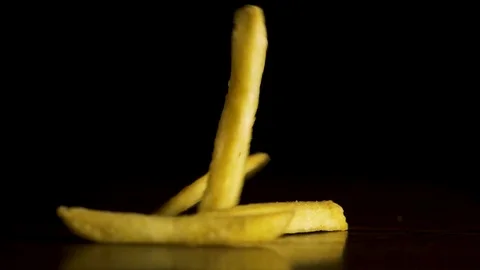 Fries falling isolated on black background. French fries fall on the table Stock Footage 84332126