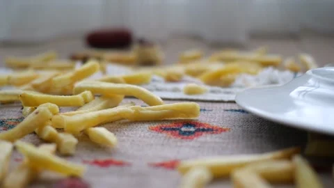 Fries spilled on a table in a home setting Stock Footage 334908835