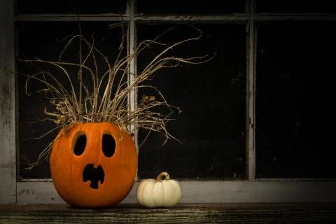 Frightened Jack-O-Lantern on a Dark Window Ledge Stock Photos
