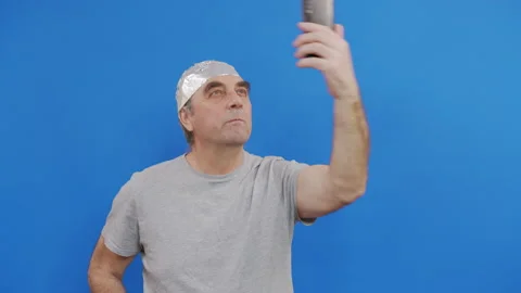 Frightened man in a tinfoil hat waved off the 5G waves.5G tower radiation Stock Footage 143984437