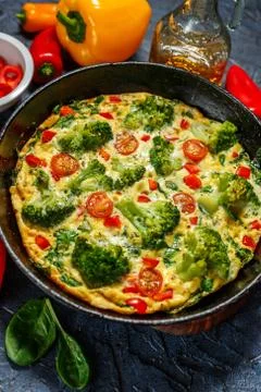 Frittata with broccoli in a frying pan. Stock Photos
