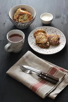 Fritters of zucchini with tea on rusticbackground Stock Photos