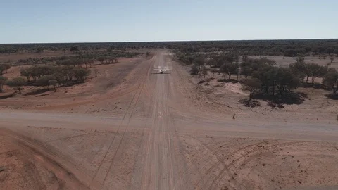 Front aerial view tracking landing Cessna 172 plane on dirt airstrip 스톡 동영상 92557071