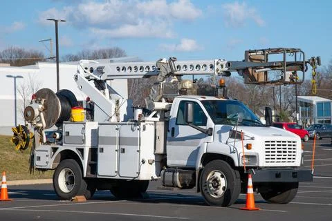 Front and side view of parked communication utility trucks in residential nei Stock Photos