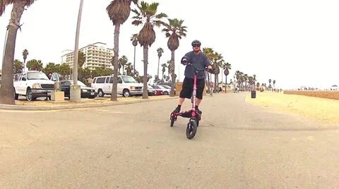 Front Angle Man Riding Trikke On Boardwalk At Huntington Beach, CA Stock Footage