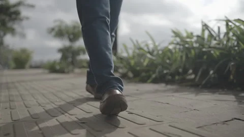 Front angle of Person walking wearing brown shoes and jeans Video stock 325436981