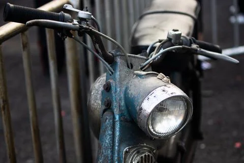 Front angle view of vintage blue motor scooter headlight with handlebar and.. Stock Photos