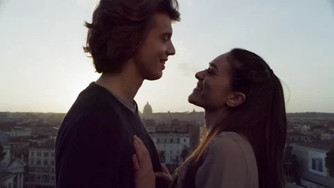 In front of a balcony overlooking the city a happy, Italian couple embrace each Video stock 199459257
