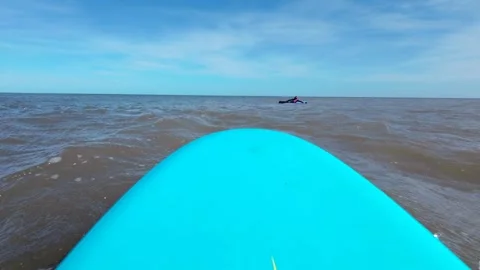 Front of blue surf board moving through water towards surfer Stock Footage 272589860
